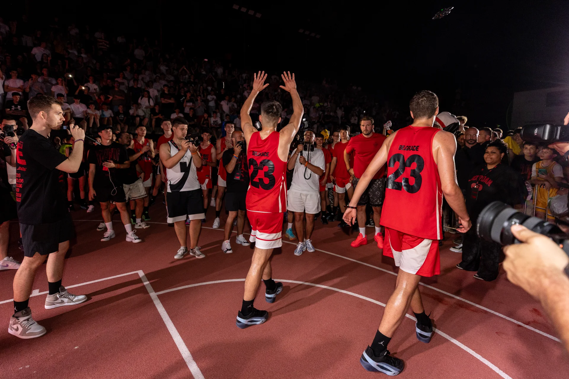 Players in red Belgrade jerseys greeting the crowd at Jordan The One
