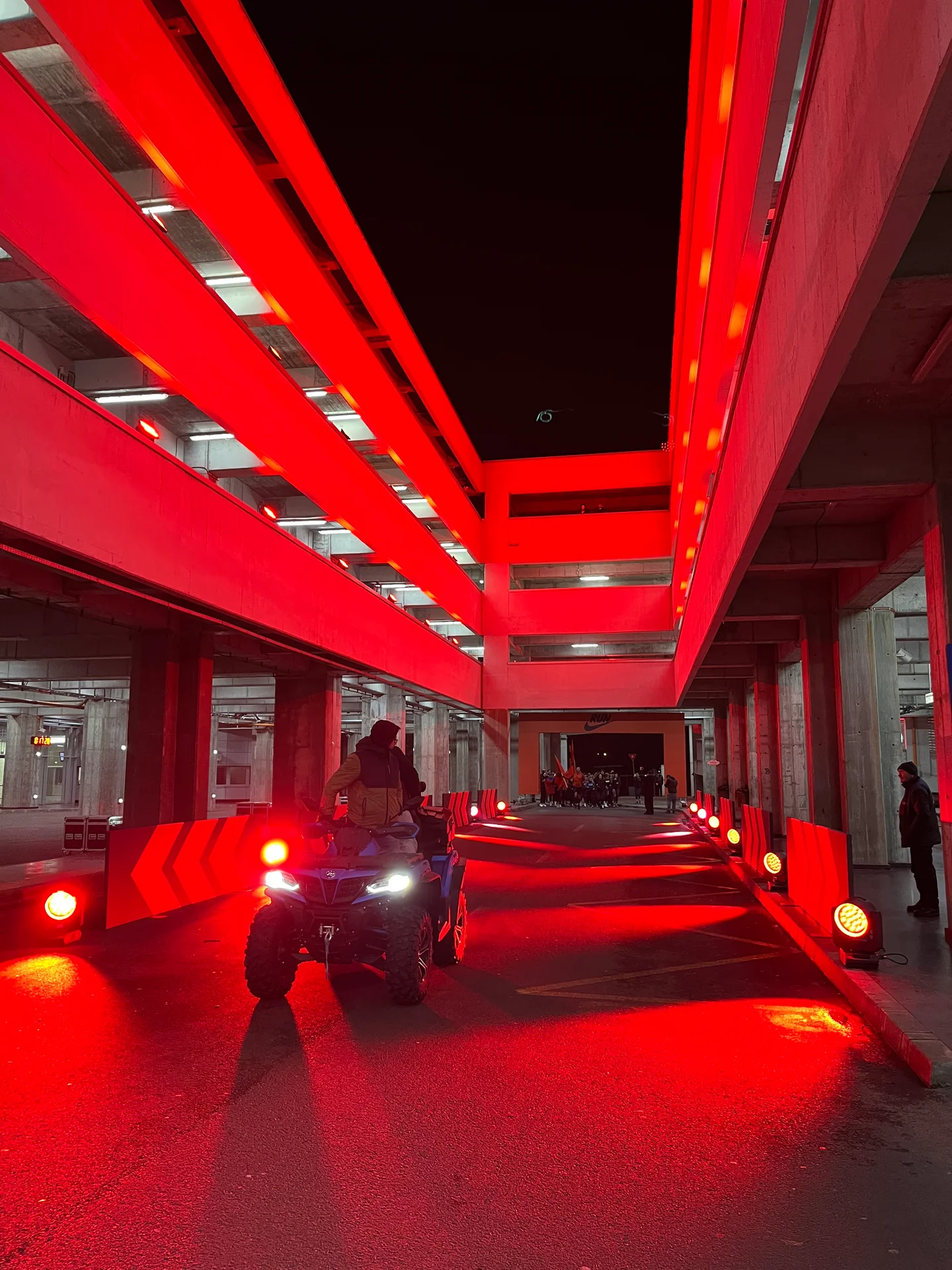 Quad bike on the red-lit course inside a multilevel parking garage at Nike Midnight Run